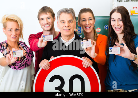 Fahrschule - Fahrlehrer und Schüler Treiber Blick auf ein Tempo 30 Schild, im Hintergrund sind Verkehrszeichen Stockfoto