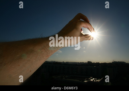 Hand nehmen die Sonnenstadt in Dunkelheit Stockfoto