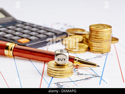 Würfel Cube mit Word kaufen, steigende Stapel von Münzen, schwarz-Rechner und den Stift auf finanzielle Diagramm Stockfoto