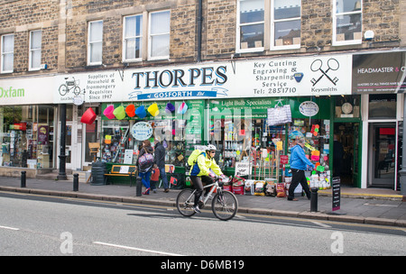 Radsportler, die vorbei Thorpes Hardware shop Gosforth High Street North East England UK Stockfoto