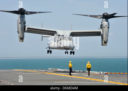 US Navy Flight Operations Segler direkt ein MV-22 Osprey Flugzeug auf dem Deck des Mehrzweck amphibischer Angriff Schiff USS Bataan 10. April 2013 in den Atlantischen Ozean zu landen. Stockfoto