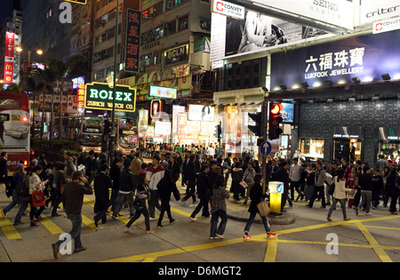 Hong Kong, China, Menschen eine Straße in der Nacht in Kowloon District überqueren Stockfoto