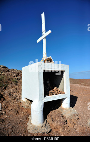 Ein Kreuz auf dem Vulkan, Montana Roja, ein beliebtes Ziel für Urlauber in Playa Blanca, Lanzarote. Stockfoto