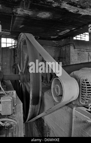 Rostigen Rad Riemenantrieb Maschinen in verlassenen Fabrik innen. Schwarz und weiß. Stockfoto