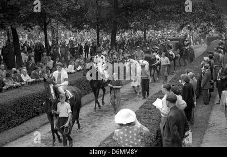 Pferde und Jockeys sind auf dem Rasen, Hoppegarten, DDR geführt. Stockfoto