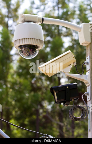 Zwei Video-Überwachungskamera und ein Notlicht werden zu einem Outdoor-Pol für Sicherheit montiert. Stockfoto