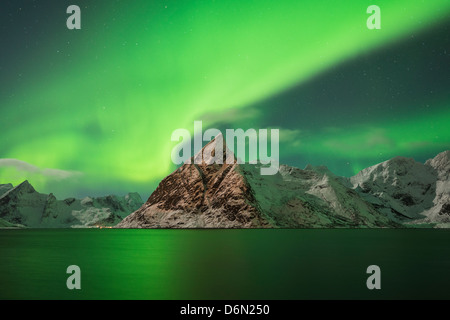 Aurora Borealis - Polarlichter Füllung Himmel über Olstind Berggipfel und spiegeln in Fjord, Toppøya, Lofoten Inseln, Norwegen Stockfoto