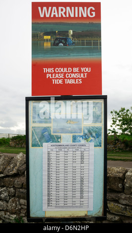 Großbritannien, Holy Island Causeway Warnschild, Gezeiten Tabelle Spielplan Stockfoto