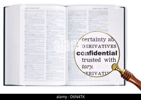 Vergrößert eine Lupe über ein Wörterbuch das Wort vertraulich betrachten gehalten Stockfoto