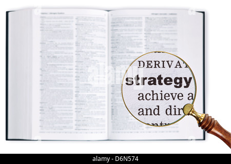 Vergrößert eine Lupe über ein Wörterbuch das Wort Strategie betrachten gehalten Stockfoto