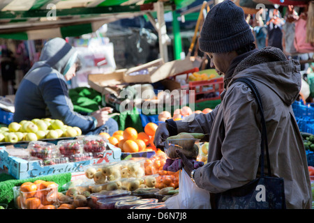 Frau kaufen Obst am Stall auf Brixton Market, Electric Avenue in Brixton - London-UK Stockfoto