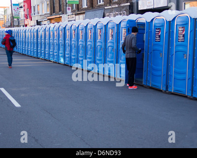 Eine Person betritt eine tragbare Toilette, während andere entlang des Ufers von mobilen Toiletten an der Toronto Yonge Street 10 K laufen Spaziergänge Stockfoto