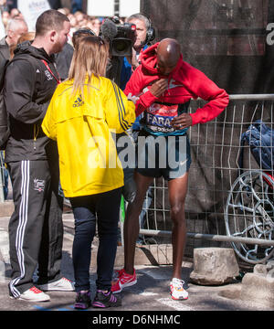 LONDON, East Smithfield, 21. April 2013.  Mo Farah, Somalias geboren und Team GB Doppel Olympia-Medaillengewinner im 5.000 m und 10.000 m in London 2012, dons des Sponsors Sweatshirt nach Beendigung seiner Rasse, kurz vor Meile 13.  Vor dem Rennen hatte Farah gesagt, er wolle mit der Elite Männer-Marathon-Läufer bis zur Mitte zu bleiben und das tat er. Stockfoto