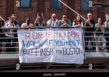 LONDON, untere Thames Street, 21. April 2013.  Zuschauer von der Virgin London-Marathon, stehen vor einem Banner Hilfe für die Opfer des Boston-Marathons, Bombardierung, die fünf Tage vorher stattfand. Stockfoto