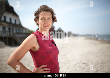 Heiliger Hafen, Deutschland, ist Frau am Halbinsel Graswarder Heiligen Hafen am Strand erholen. Stockfoto