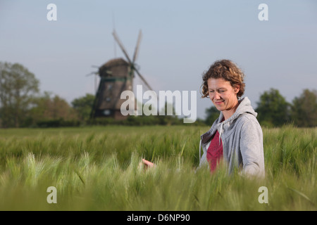 Wangels, Deutschland, Frau schaut Wintergerste auf ein Getreidefeld Stockfoto