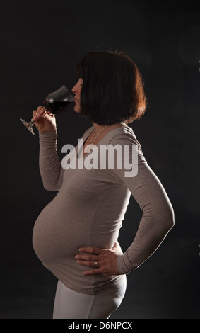 Freiburg, Deutschland, eine schwangere Frau mit einem Glas Rotwein Stockfoto