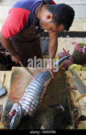 Muscat, Oman - 26. März 2013: Unbekannter Oman Fischhändler in Mutrah Fischmarkt Thunfisch Steaks schneiden. Stockfoto