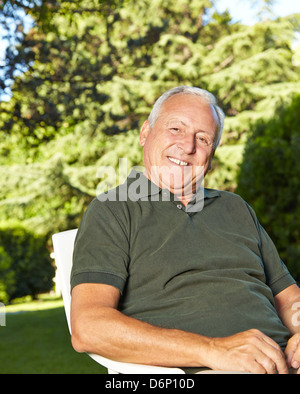 Glückliches Alter Mann sitzen im Sommergarten Stockfoto