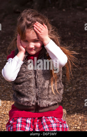 5 Jahre altes Mädchen mit langen braunen Haaren, gekleidet In warme Kleidung außerhalb Stockfoto