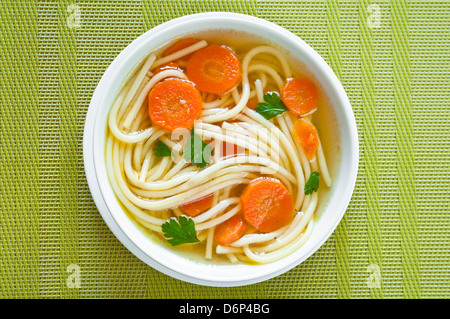 Huhn Suppe in eine Schüssel mit Möhren und Petersilie Stockfoto