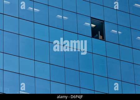 Eine fehlende Glasscheibe in einem "Glaskasten" Gebäude dient als ein Symbol oder eine Metapher für eine unzählige Dinge. Stockfoto