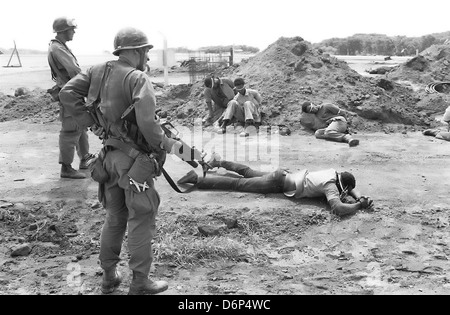 US-Marines bewachen aufgenommene Mitglied der Völker revolutionäre Armee während der Invasion von Grenada, unter dem Codenamen Operation Urgent Fury 25. Oktober 1983 in St. Georges, Grenada. Die Invasion begann am 25. Oktober 1983 und wurde die erste größere militärische Aktion von den Vereinigten Staaten seit dem Ende des Vietnam-Krieges. Stockfoto