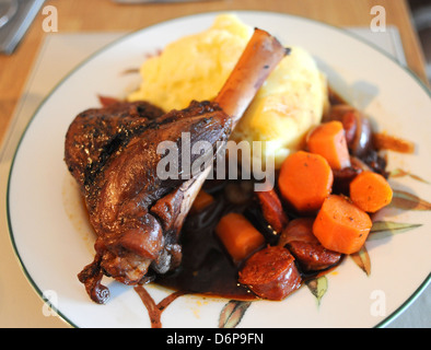 Lammschenkel langsam in Rotwein serviert mit Knoblauch Kartoffelpüree Kartoffeln und Karotten gekocht Stockfoto