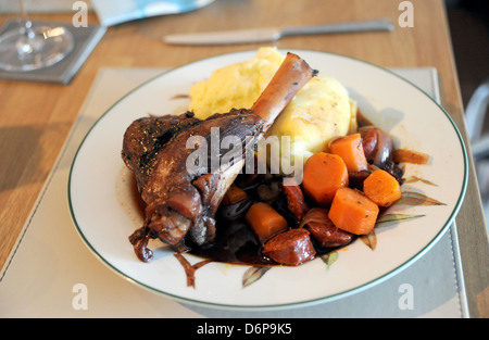 Lammschenkel langsam in Rotwein serviert mit Knoblauch Kartoffelpüree Kartoffeln und Karotten gekocht Stockfoto