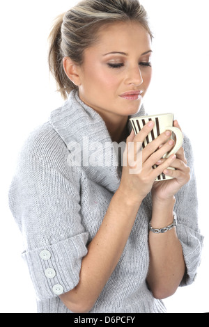 Frau alleine Halten und trinken Sie eine Tasse heißen Tee oder frisch gebrühten Kaffee Bestandsaufnahme und Denken in einen Moment der Entspannung, gegen Weiße Stockfoto