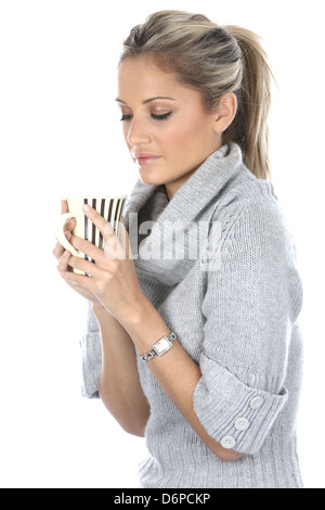 Frau alleine Halten und trinken Sie eine Tasse heißen Tee oder frisch gebrühten Kaffee Bestandsaufnahme und Denken in einen Moment der Entspannung, gegen Weiße Stockfoto