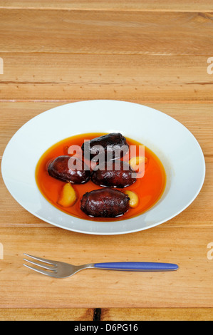 Stücke der spanischen Chorizo-Wurst mit ganzen Knoblauchzehen in Olivenöl Tapas, Costa Del Sol, Andalusien, Spanien, Westeuropa. Stockfoto