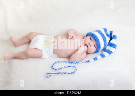 Säugling Baby weared lustigen Hut liegen auf einer Decke Stockfoto