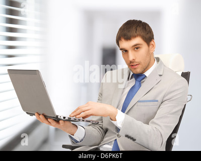 junger Geschäftsmann sitzt im Stuhl mit laptop Stockfoto