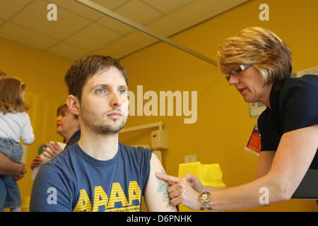 Swansea, Großbritannien. 20. April 2013 im Bild L-r: 32 Jahr alt Geraint Evans von Briton Ferry hat seine MMR-Impfstoff von einer Krankenschwester in Neath Port Talbot Krankenhaus, Port Talbot, South Wales.  Re: Drop-in MMR-Kliniken sind in vier Krankenhäusern in Swansea, Großbritannien und Neath Port Talbot, statt, wie der Tod eines Menschen, verbunden mit der Masernausbruch untersucht wird.  Gareth Colfer Williams, 25, starb in seinem Haus in Swansea, Großbritannien am Donnerstag.  Tests von Public Health Wales haben bestätigt, dass er zum Zeitpunkt seines Todes Masern hatte.  Die Anzahl der gemeldeten Masernfälle in Wales liegt nun bei 808.  Es ist das dritte Wochenende in eine r Stockfoto