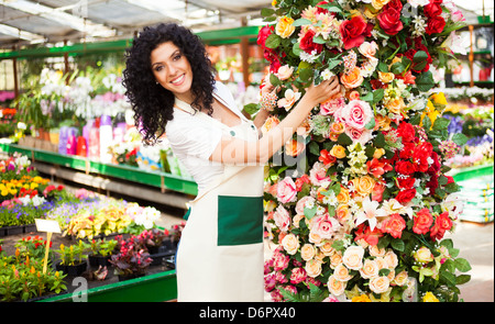 Frau bei der Arbeit in einem bunten Gewächshaus Stockfoto