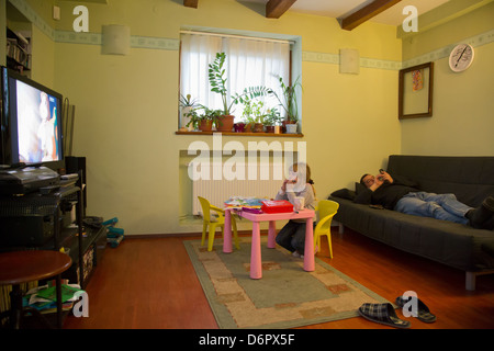 Wroclaw, Polen, sieht eine Mädchen bei einer Zeichentrickserie im Fernsehen, ihr Vater auf dem sofa Stockfoto