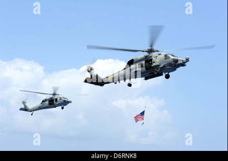 In Bildung 23. April 2013 in den Pazifischen Ozean fliegen uns Marine MH-60R Sea Hawk und MH-60 s Ritter Hawk Hubschrauber aus dem Flugzeugträger USS John C. Stennis. Stockfoto