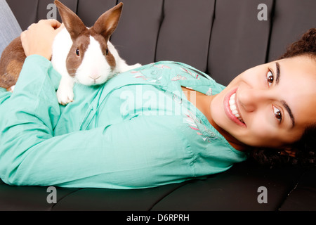 Eine junge, brasilianische Frau mit einem Kaninchen. Stockfoto