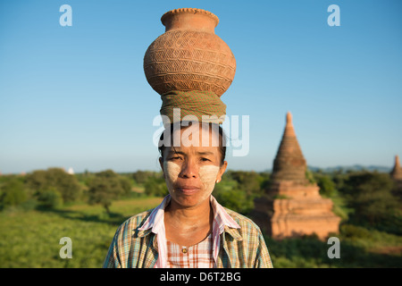 Porträt des asiatischen traditionellen Bauern tragen Tontopf auf Kopf wieder nach Hause gehen, Bagan, Myanmar Stockfoto