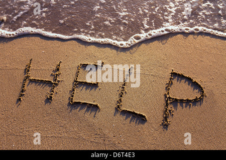 Word Hilfe handschriftlich auf dem sand Stockfoto