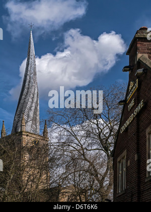 CHESTERFIELD, DERBYSHIRE, Großbritannien - 18. APRIL 2013: Chesterfield Cathedral mit seinem krummen Spire, der neben einem Pub namens The Crooked Spire steht Stockfoto