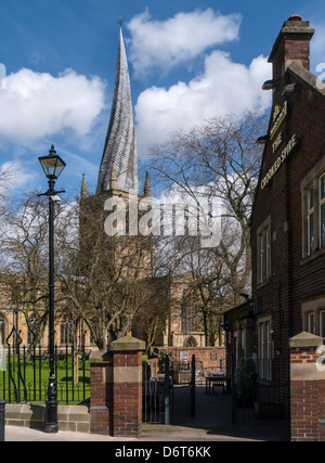 CHESTERFIELD, DERBYSHIRE, Großbritannien - 18. APRIL 2013: Chesterfield Cathedral mit seinem krummen Spire, der neben einem Pub namens The Crooked Spire steht Stockfoto