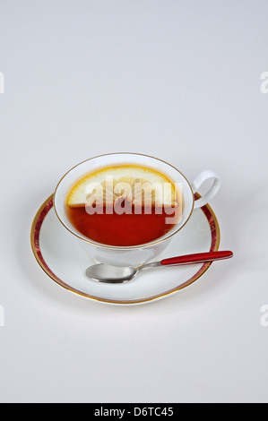 Schwarzer Tee mit einer Zitronenscheibe im China Wasserglas. Stockfoto