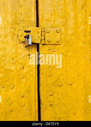 Auf eine alte gelbe Metall Tür schloss Stockfoto