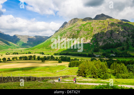 Wanderer im Langdale Tal mit Langdale fiel und Mickleden Tal in der Ferne. Seenplatte, Cumbria, England. Stockfoto