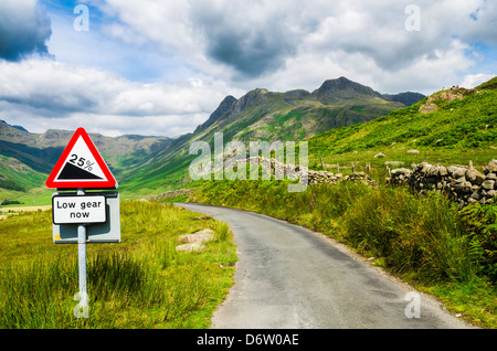 Steile Hügel Warnzeichen auf der Straße mit Blick auf Langdale fiel in der Seenplatte, Cumbria, England. Stockfoto