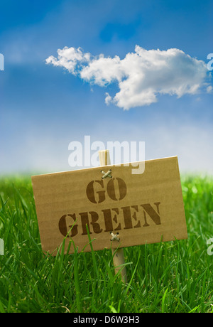 Gehen Sie grünen Text geschrieben auf einem Karton Board Rasen blauen Himmel Stockfoto