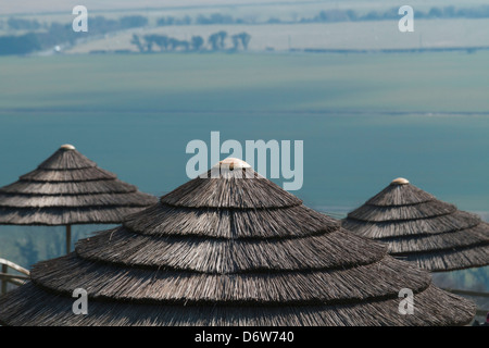 Drei 3 Stroh Reed Grass gedeckte Dach Dächer Dach Sonne Schatten Schattierungen Sonnenschirm Sonnenschirme Stockfoto