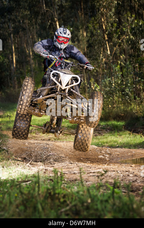 Quad Fahrer springen auf einem Waldweg. Stockfoto